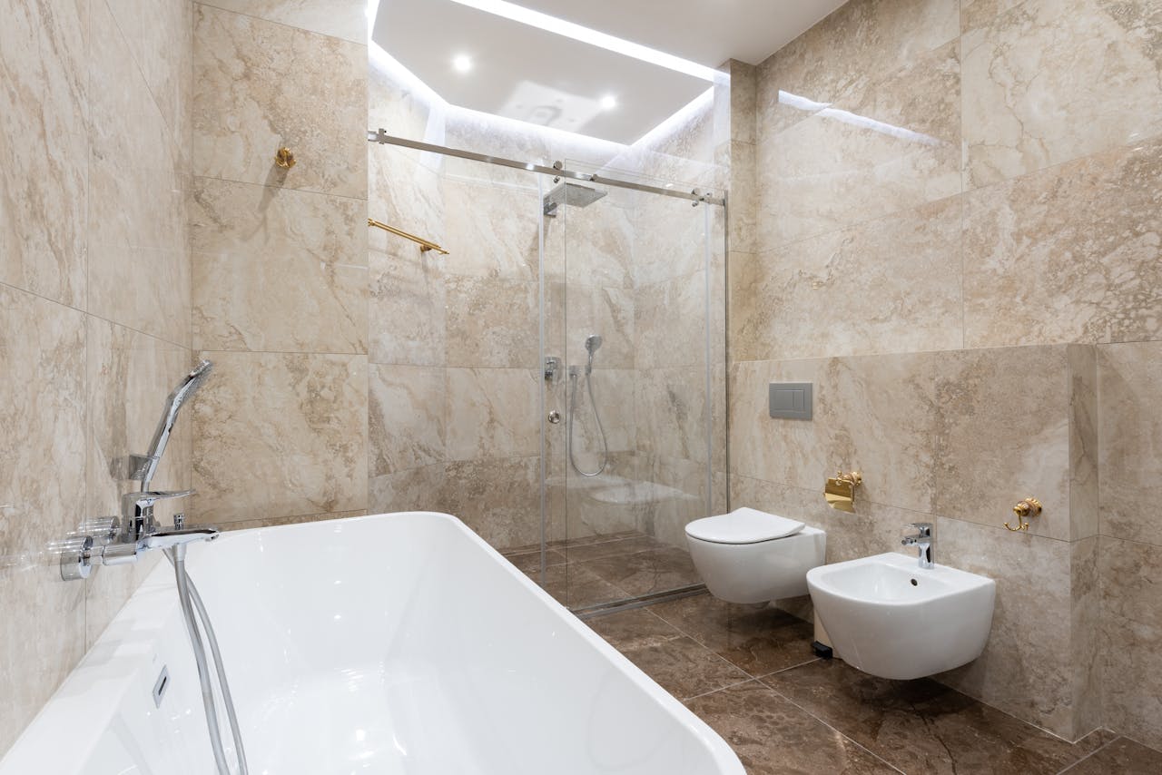 Modernes Marmorbad mit Badewanne, Glasdusche, Toilette und Bidet
